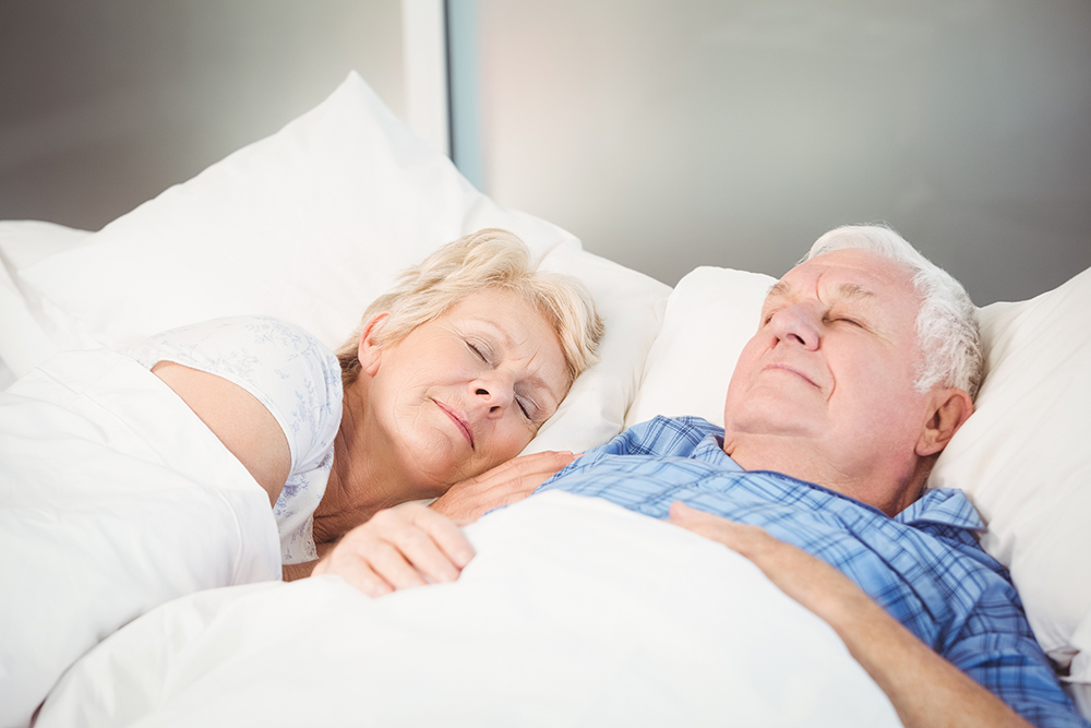 Older couple sleeping peacefully, symbolizing sleep disorder treatment success